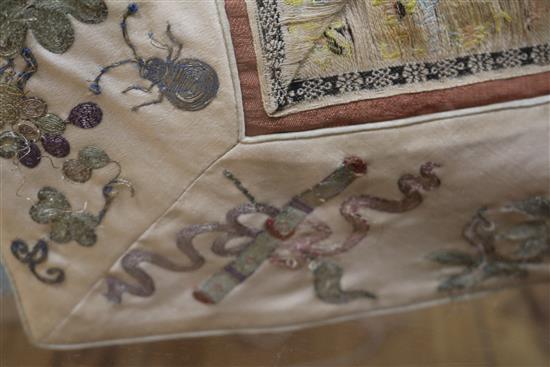 A Chinese embroidered silk and metal thread tunic, perspex case